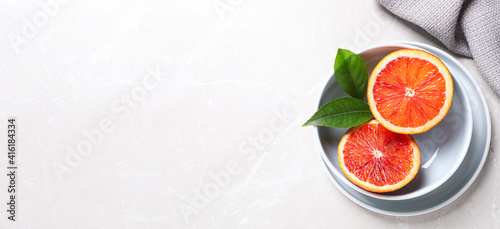 Slices of fresh ripe red orange on light table  flat lay. Space for text