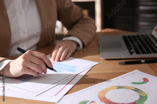 Businesswoman working with charts and graphs at table in office, closeup. Investment analysis © New Africa