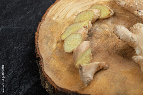 Fresh gingers rhizome or root on a wooden board