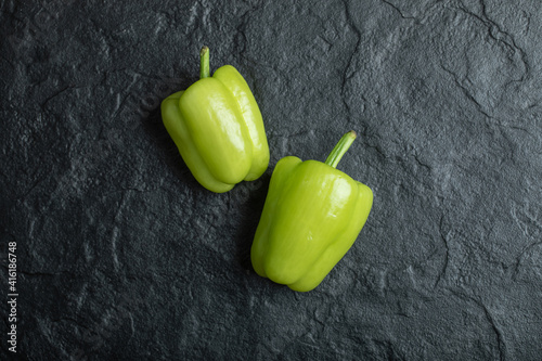 Fresh green bell peppers on a dark background