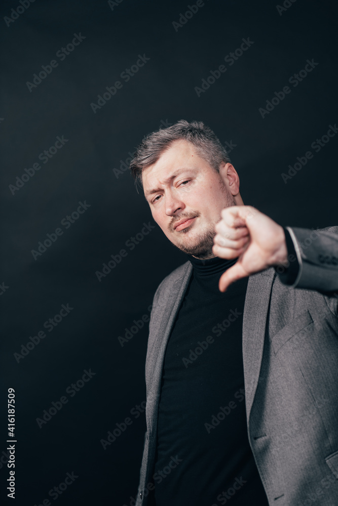 Dissatisfied serious man show thumb down gesture