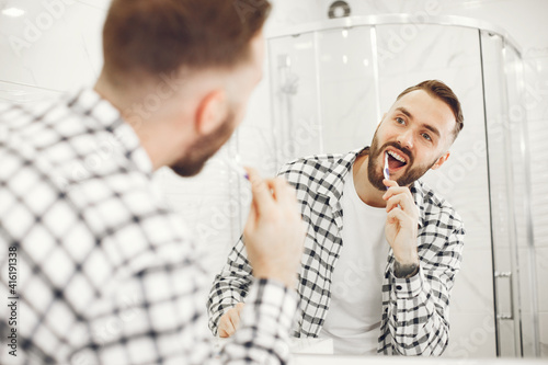 Man in a home bathroo. Health and well being teeth care and grooming, indoors.