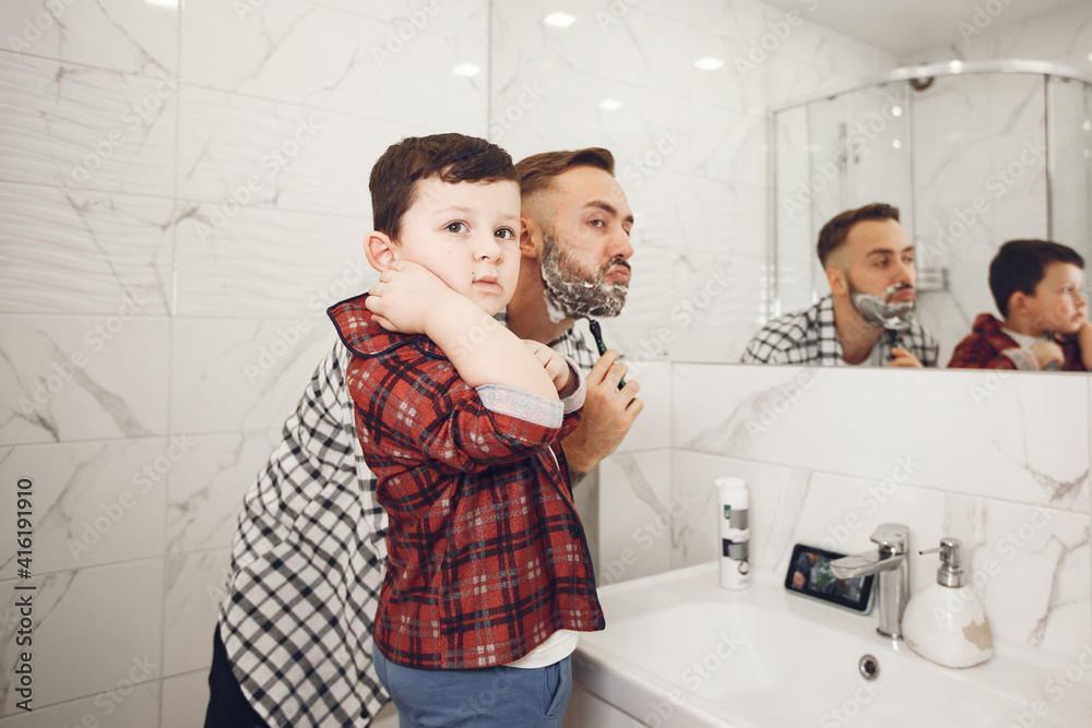 Father teaching his son to shave isolated. People with shaving foam in the bathroom. Father teaching his son to shave isolated. People with shaving foam in the bathroom.
