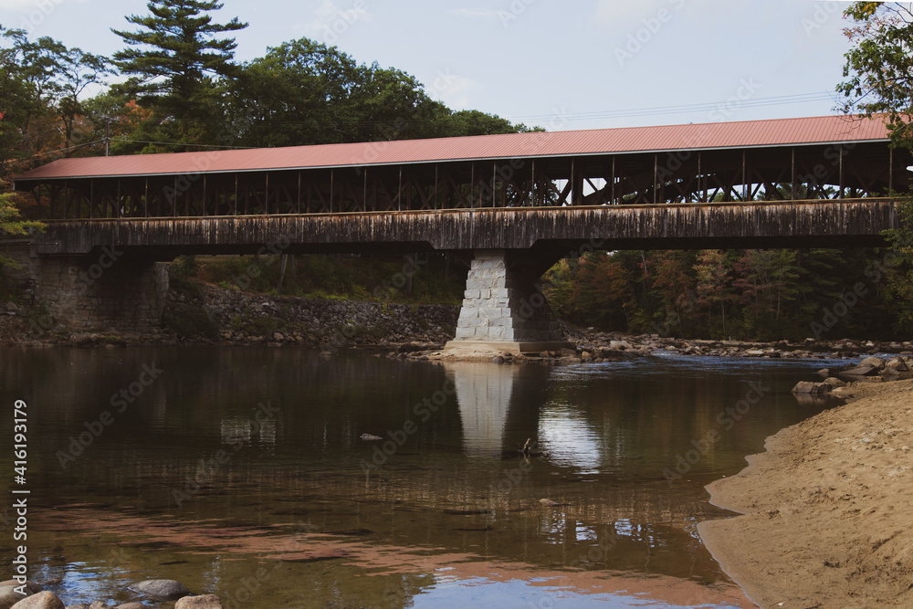 covered bridge over a calm river covered bridge over a calm river
