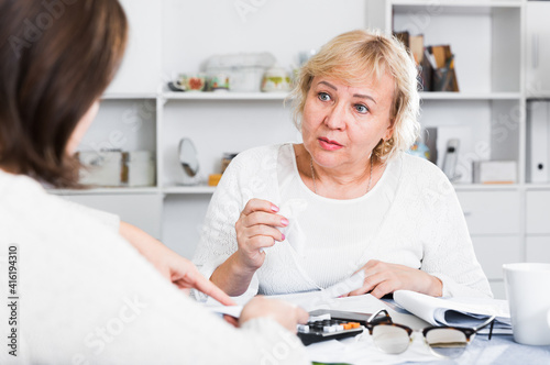 Mature woman consults with a financial adviser for the proper conduct of home accounting