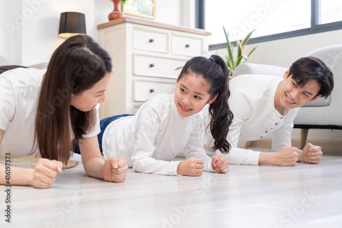 Young Asian family doing exercise together at home