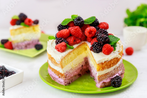 Tasty berry cake decorated with fresh raspberries and blackberries.