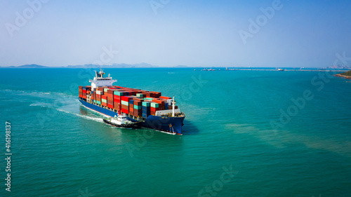 tug boat drag container ship in shipping port area, thailand.