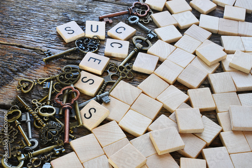 A close up image of tiles spelling out "success" on an old wooden table.  