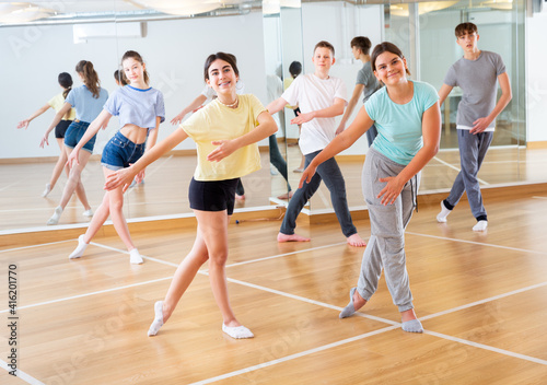 Dancing group of five teenagers practicing new dance in studio