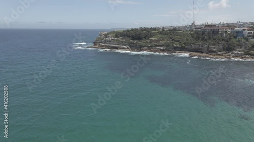 Calm Blue Sea With Mackenzies Point Peninsula In Background In Tamarama, NSW, Australia. - aerial photo