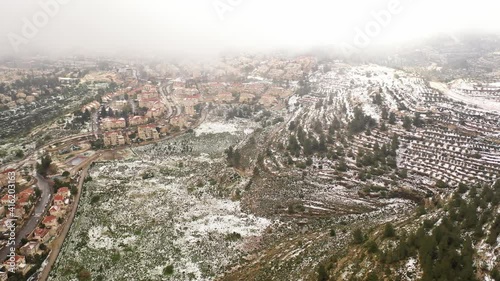 Jerusalem high hills in the snow aerial view
,drone view over mevasert zion close to Jerusalem covered with snow, February 2021
 photo