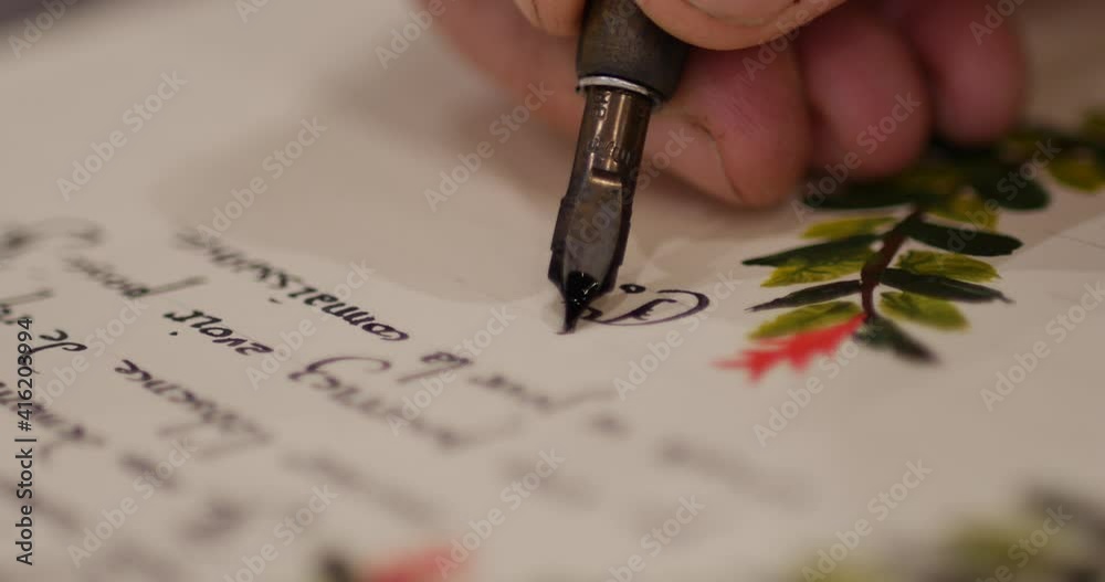 Man writing a embellished letter with calligraphy gothic letters. Man writing an old letter. Old quill pen, books and papyrus scroll on the table. Historical atmosphere. writing a document on a sheet