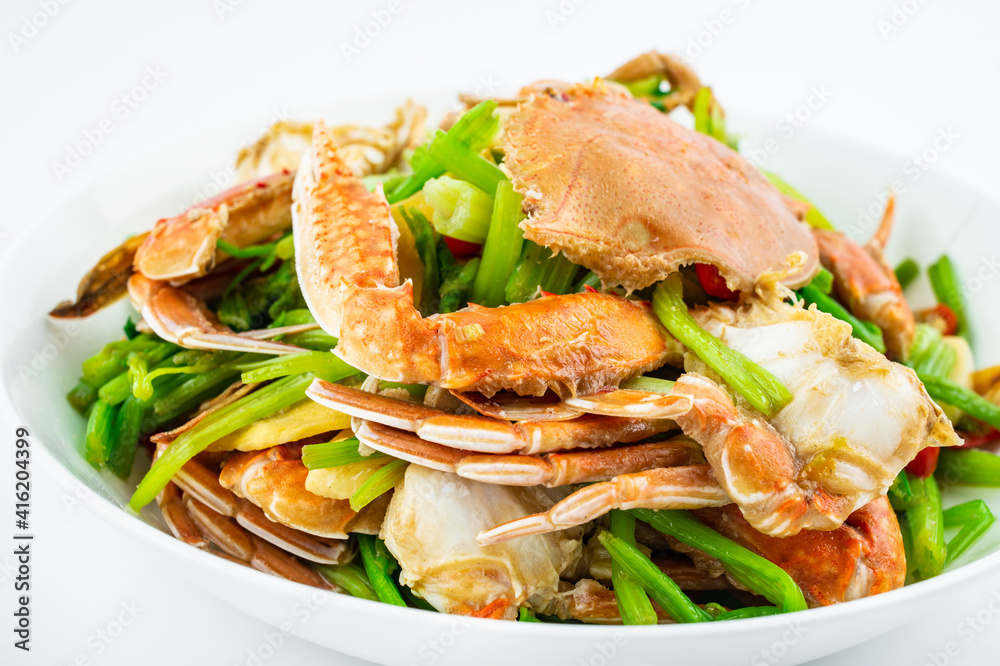 Fried flat crab with celery on a plate on white background Fried flat crab with celery on a plate on white background