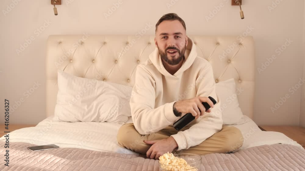 Leisure time. Amazed young bearded man wearing casual clothes watching movie film. Leisure time. Amazed young bearded man wearing casual clothes watching movie film.