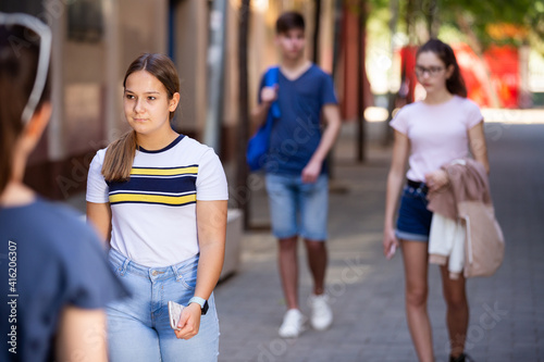 Positive young teen girl walks down the street