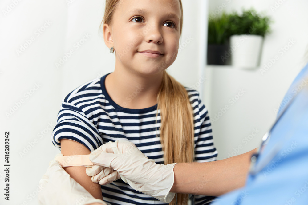 the doctor seals the hand of the child with a plaster close-up the doctor seals the hand of the child with a plaster close-up