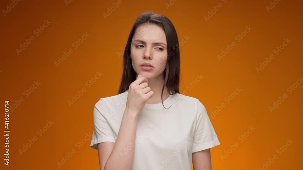 Blonde woman thinking over smart idea, pondering, against yellow background Blonde woman thinking over smart idea, pondering, against yellow background