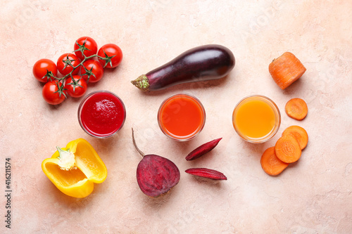 Composition with glasses of different smoothie and vegetables on color background