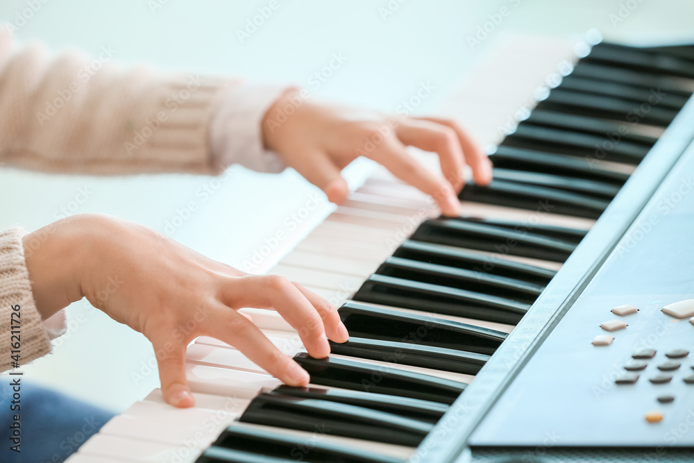 Obraz premium Little girl playing synthesizer at home, closeup