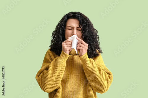 Sick young woman on color b...