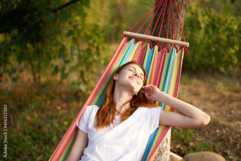 happy woman lies in a hammock outdoors in the forest laughing smile model happy woman lies in a hammock outdoors in the forest laughing smile model