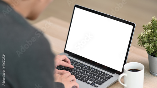 Close up view of young man using computer laptop in living room.
