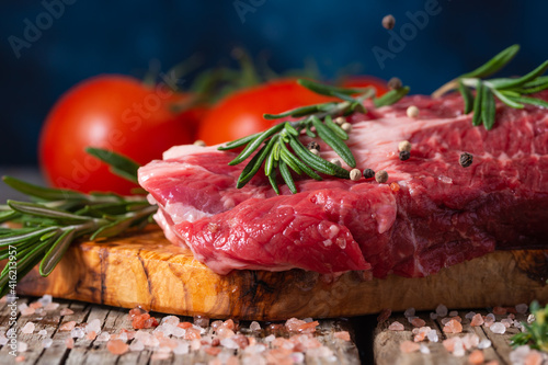 fresh beef steak with rosemary. Vegetables sprinkled with black peppercorns on the background, freeze in motion