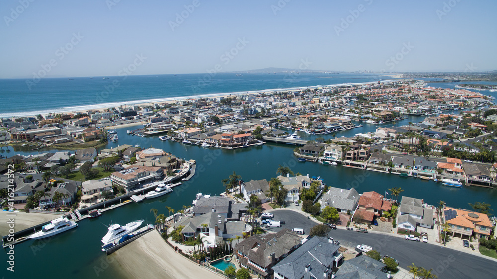 Aerial view of a neighborhood nestled inside a harbor, next to the ocean