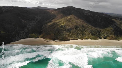 Aerial panning shot from left to right at te Werahi Beach, Cape Reinga, New Zealand photo