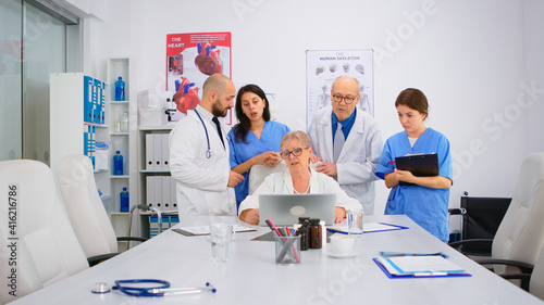 Brainstorming teamwork of physicians solving problem related to illnesses of patients in modern hospital conference room office. Medical examination  coworker consulting with mentor or chief physician