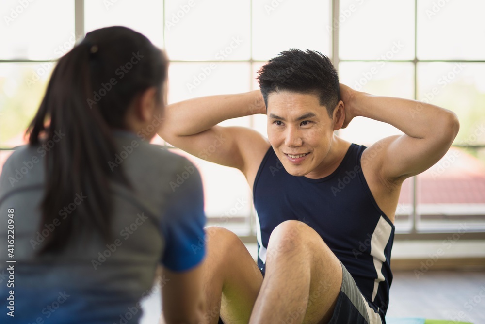 Adult asian man and woman family wearing sport outfit do exercise workout for healthy self care at home