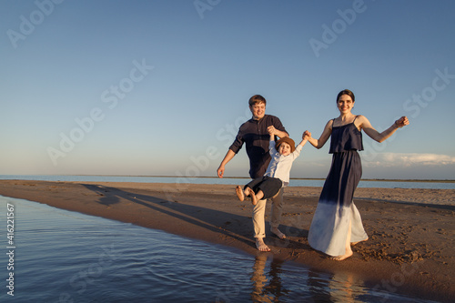 Young family with child have fun on the beach. Copy space.