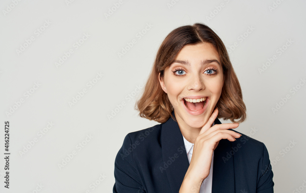 Energetic business woman in a suit gestures with her hands on a light background Copy Space Energetic business woman in a suit gestures with her hands on a light background Copy Space
