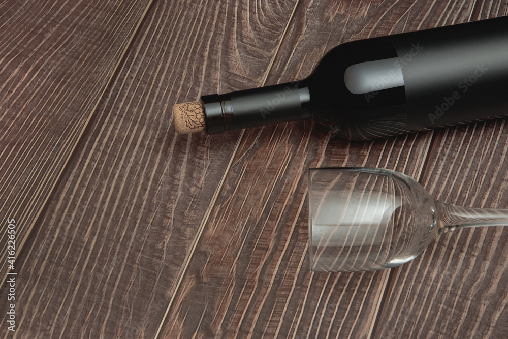 Naklejka premium Wine glass and collectible bottle of wine on wooden background with old texture