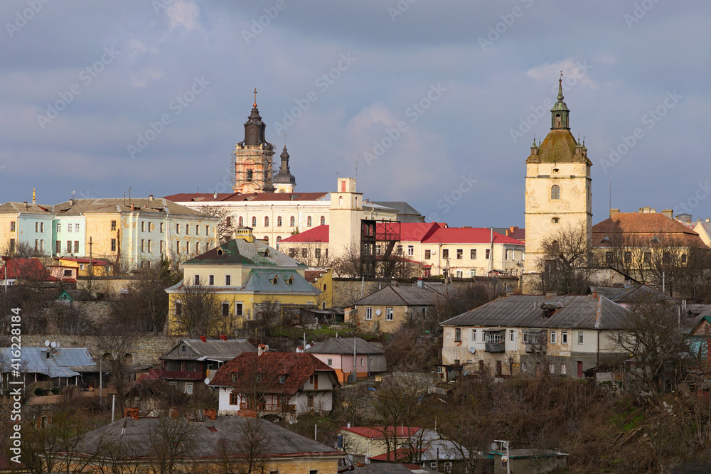 Scenic aerial landscape view of historic part of the Kamianets-Podilskyi. Cloudy winter day. Different colorful residential houses on the hill. Canyon of Smotrych River, Ukraine
