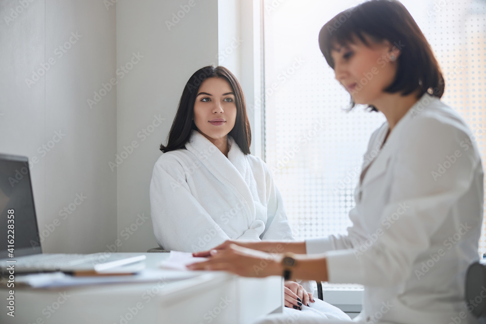 Doctor reading her patient electrocardiogram at the desk Doctor reading her patient electrocardiogram at the desk