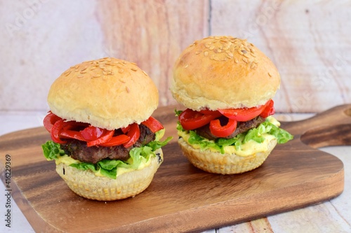homemade beef burger with red bell peppers, lettuce and curry mayonnaise sauce
