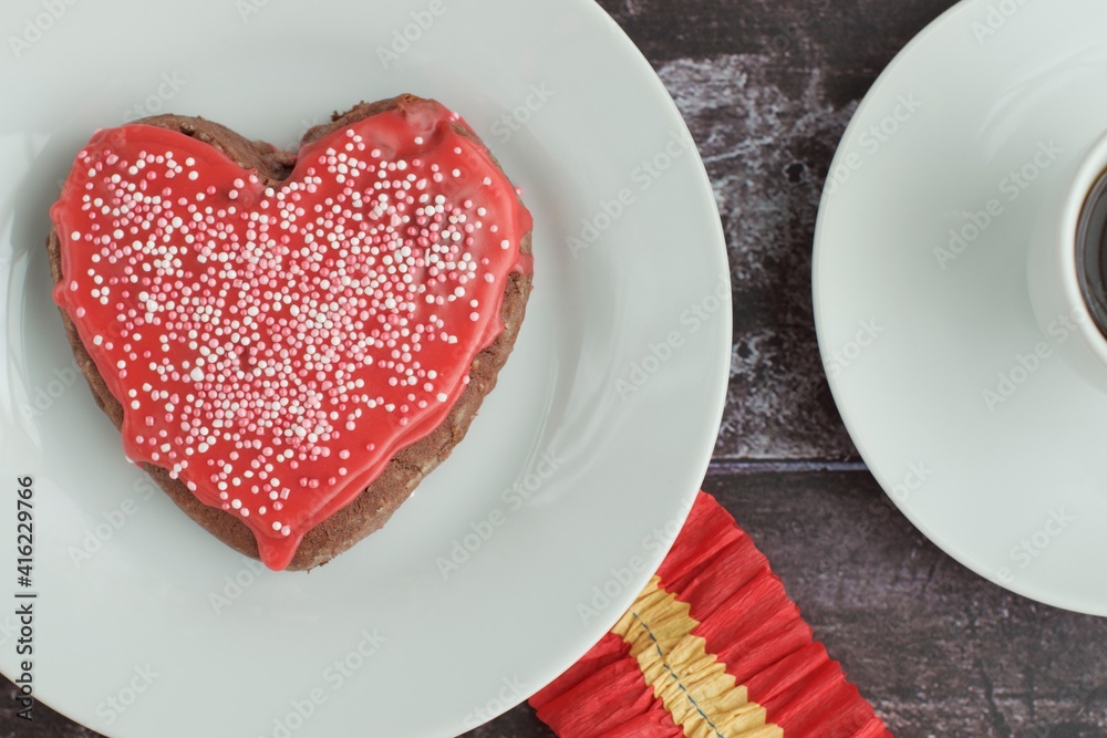 Heart shaped Valentine's cookie with red sugar glaze and sprinkles Heart shaped Valentine's cookie with red sugar glaze and sprinkles