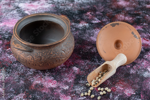 Ancient pot with beans on a colorful background