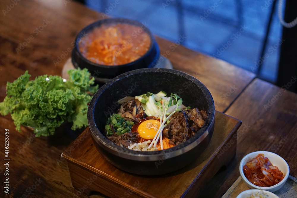 Dolsot bibimbap - Korean mixed rice, Include steamed rice, vegetables, pork and fried egg on top, served in a hot stone pot. Dolsot bibimbap - Korean mixed rice, Include steamed rice, vegetables, pork and fried egg on top, served in a hot stone pot.