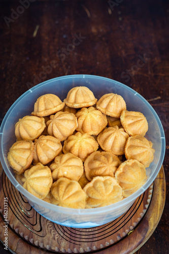 Kuih Bahulu, baulu or bolu in a container. Sponge cake baked in special aluminium moulds is the Asian tradition food in popular Malaysia and Indonesia. photo