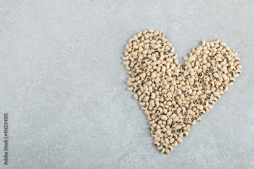 Many of raw white healthy kidney beans on a gray background
