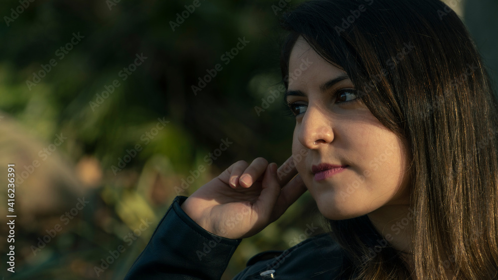 Rostro de mujer joven mirando al frente con la mano en la cabeza Rostro de mujer joven mirando al frente con la mano en la cabeza