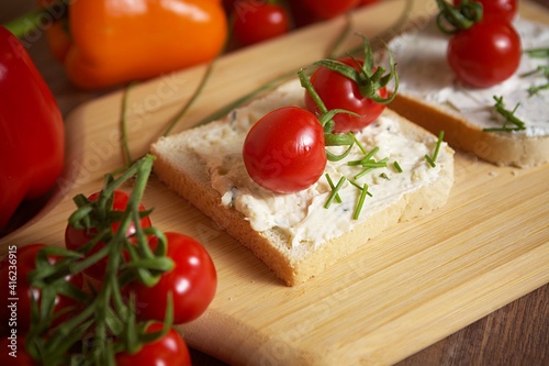 toast bread with tomato and pepper spread and chives on a wooden board