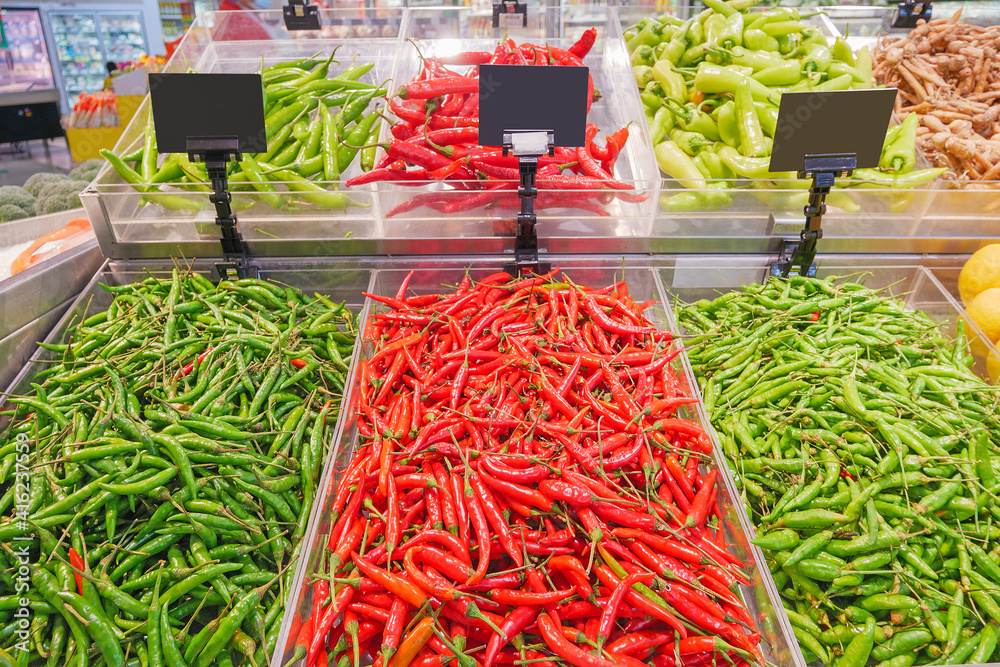 Red and green chilli peppers on a stall..