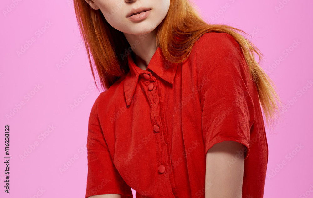 Charming woman in a red dress on a pink background gestures with her hands Copy Space Charming woman in a red dress on a pink background gestures with her hands Copy Space