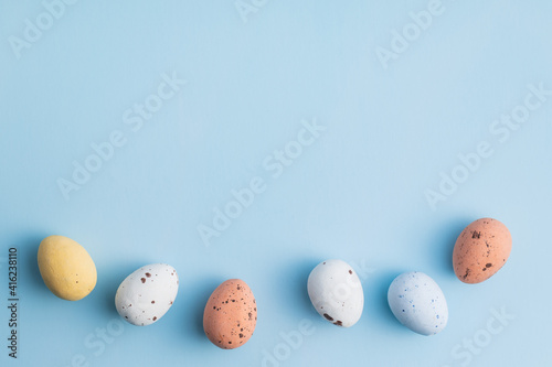 Colorful chocolate easter eggs. Sweet candy eggs on blue background.