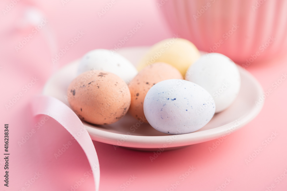Fototapeta premium Colorful chocolate easter eggs. Sweet candy eggs on pink background.