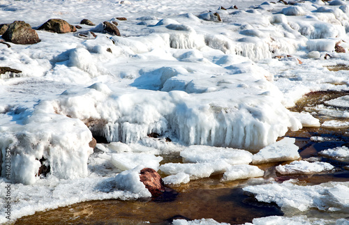 Ice covered rocky coast of the Baltic Sea on wintertime in Latvia.White snow, ice covers the land on seaside.
